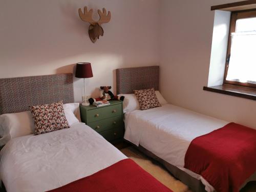 埃斯特里-德阿内乌Privilege La Bonaigua的一间卧室设有两张床,在梳妆台上摆放着泰迪熊