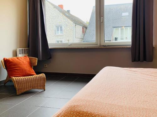 布莱蒙Appartement Vallee de la Meuse - Esc'Appart的卧室配有床、椅子和窗户。