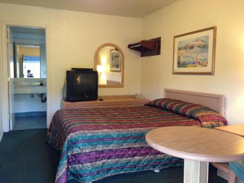 瓦列霍探索旅馆 的一间酒店客房,配有一张床和一台电视