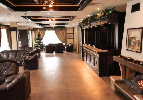 班斯科Park Hotel Panorama的大型客厅配有皮革家具和圣诞树