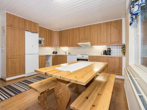 伊萨尔米Holiday Home Oriaho by Interhome的厨房配有木制橱柜、木桌和长凳