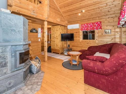 伊萨尔米Holiday Home Käenpesä by Interhome的客厅设有壁炉和红色沙发。