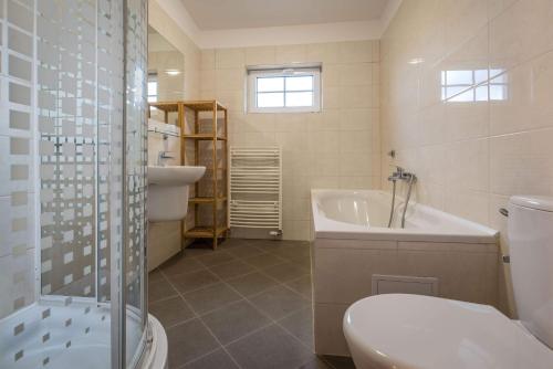 贝谢诺瓦Villapark Vlašky的浴室配有卫生间、浴缸和水槽。