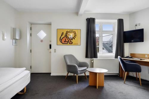 斯文堡伽尼酒店的酒店客房,配有一张床、一张桌子和椅子