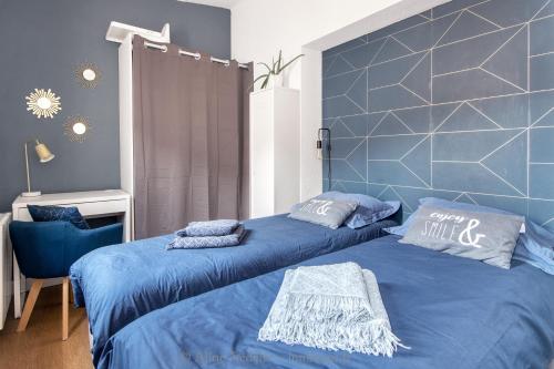 拉罗谢尔The Clock House, 3 étoiles的一间卧室配有两张蓝色床单