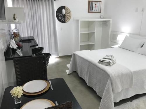弗洛里亚诺波利斯Casa das Flores的卧室配有一张床和一张桌子及椅子