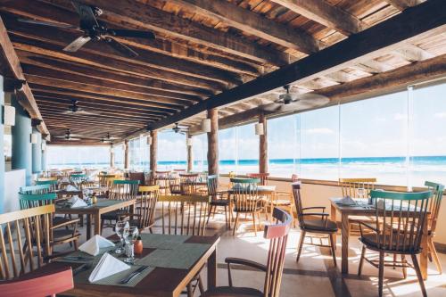 坎昆Iberostar Selection Cancun的一间带桌椅的海景餐厅