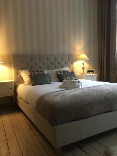 迪南La MeusÂme的一间卧室配有一张带两盏灯的大型白色床。