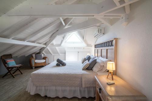 圣马丁岛Résidence La Plage Orient Bay by La Conciergerie FWI的阁楼上的卧室配有一张大床