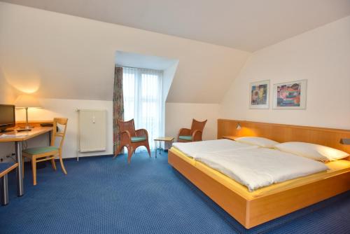 萨尔斯塔特法萨纳加特酒店的配有一张床和一张书桌的酒店客房