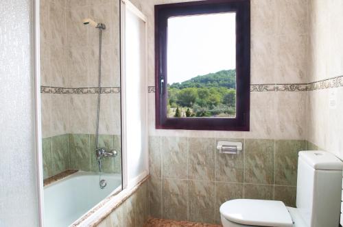 索塔Finca Aguilas的带淋浴和卫生间的浴室以及窗户。