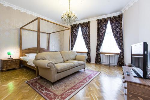 利沃夫Австрійська квартира в центрі на вулиці Михальчука 5的一间卧室配有一张床、一张沙发和一台电视