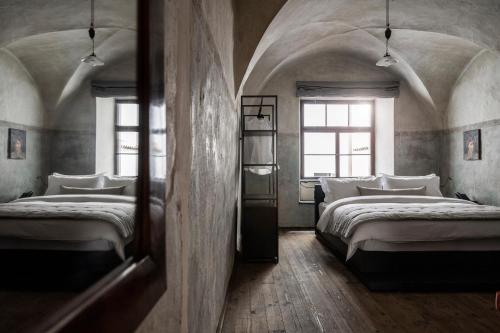 博尔扎诺Goldenstern Townhouse的带2扇窗户的客房内的2张床