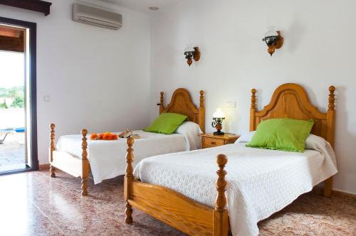 索塔Finca Aguilas的卧室内的两张床,配有绿色枕头