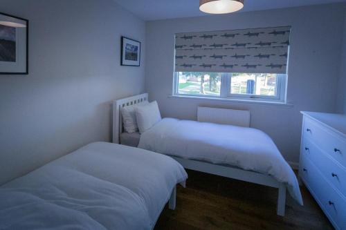 阿伯劳尔The Salmon Hut的一间卧室设有两张床和窗户。