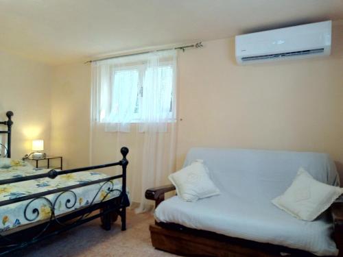 奎瑟塔Il Giardino di Patrizia的一间卧室配有一张床和一个带风扇的窗户。