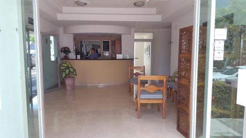 坎佩切Hotel Villa Campeche的一间带桌椅和柜台的用餐室