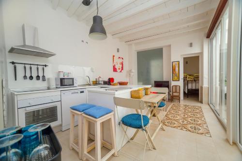 马拉加Theodora Chica 1的厨房配有白色的柜台和桌椅