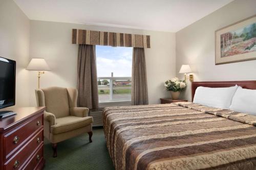 Stony Plain斯托尼平原汽车旅馆的酒店的客房 - 带一张床、椅子和窗户