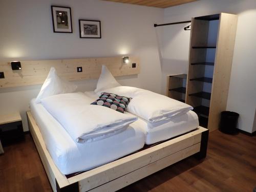 上瓦尔德富尔卡酒店的一张配有白色床单和枕头的大床