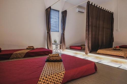 巴淡岛中心RedDoorz Apartment @ Batam Centre 3的带三张床和窗户的客房