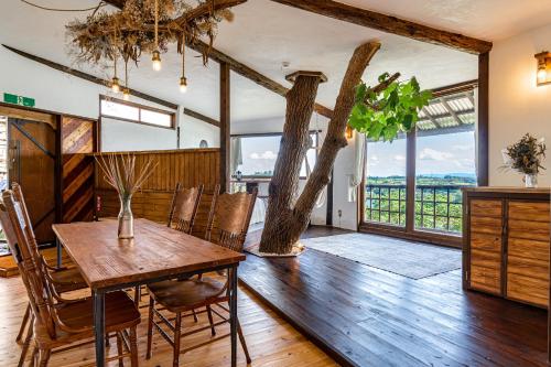 今归仁村Tree-house Hotel Morinosubako的一间配备有桌椅和树的用餐室