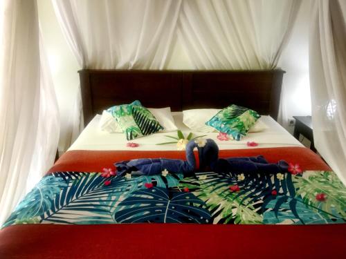 佩母德兰芒果月亮旅馆的一间卧室配有两张红色和白色的床