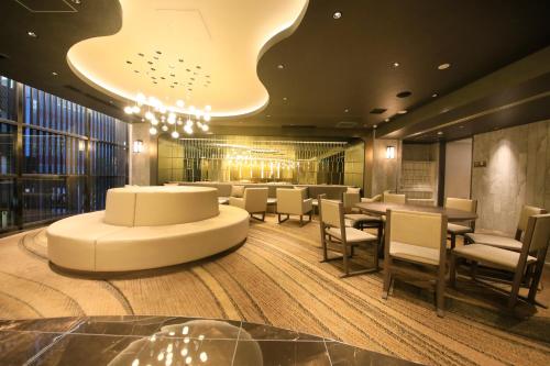 东京Quintessa Hotel Tokyo Ginza的一间带桌椅和吊灯的餐厅