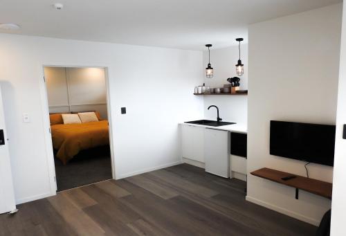 韦斯特波特The Loft Apartments的白色的客房设有床、水槽和电视。