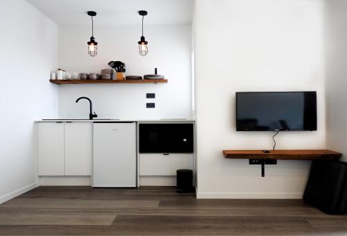 韦斯特波特The Loft Apartments的厨房配有白色橱柜和平面电视。