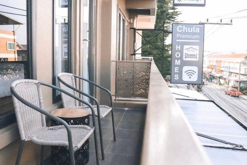 班昌Chula Premium Homes的大楼内的阳台配有椅子和标志