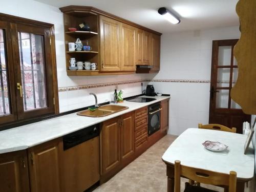 阿尔巴拉辛CASA CENTRO ALBARRACIN的厨房配有木制橱柜、水槽和桌子