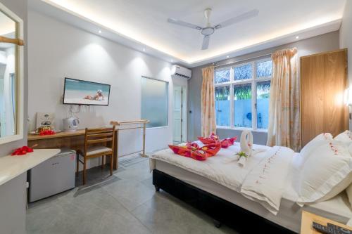 乌库拉斯Koimala Beach Ukulhas的一间卧室配有书桌和一张带白色枕头的床。