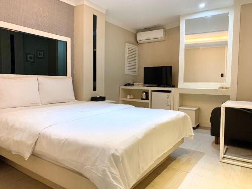 首尔公主酒店的卧室配有一张白色大床和电视。