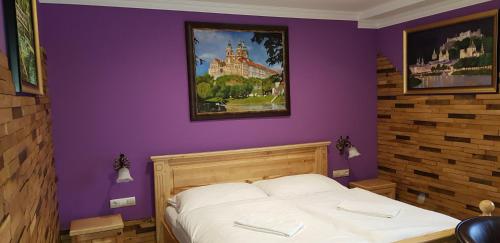 多瑙河畔伊布斯凯泽酒店的一间卧室配有一张紫色墙壁的床