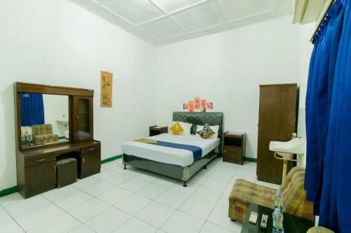 苏加武眉SUPER OYO 1707 Hotel Mustika Widyasari的一间卧室配有床、水槽和镜子