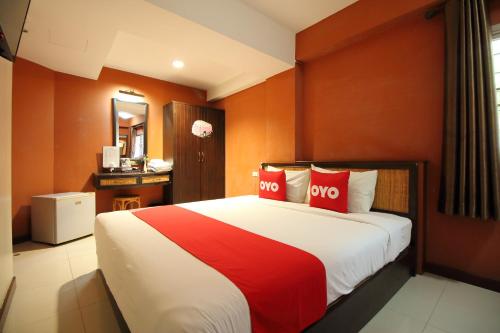 曼谷OYO 482 Pannee Lodge Khaosan - SHA Plus的一间卧室配有一张大床和两个红色枕头