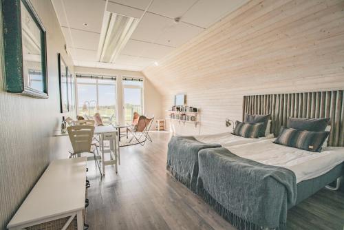 哈尔姆斯塔德Halmstad Golfarena Hotell & Lägenheter的卧室配有一张床和一张桌子及椅子