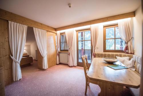 布拉伊埃斯Hotel Edelweiss的客厅配有木桌和窗户。