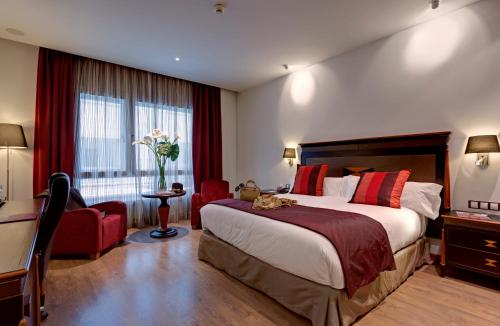 马德里Hotel Crowne Plaza Madrid Airport的酒店客房设有一张大床和一张书桌。