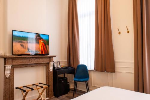 根特La Lys Rooms & Suites的客房 - 带壁炉及蓝椅和电视