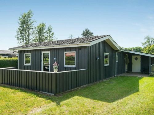 Diernæs6 person holiday home in Haderslev的黑色外墙绿色房子