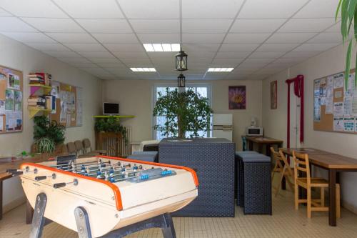 欧坦Camping d'Autun的配有桌上足球、桌子和椅子的房间