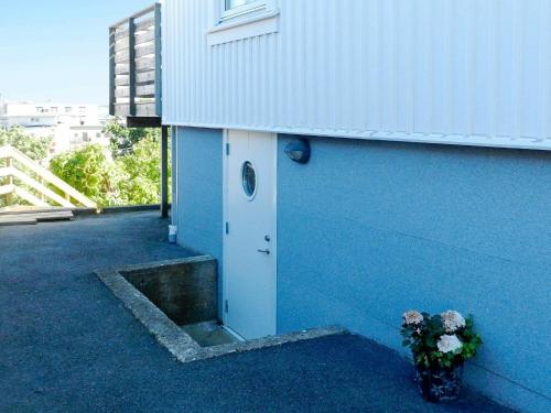 吕瑟希尔5 person holiday home in LYSEKIL的蓝色的建筑,有门和花瓶