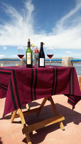 奥科苏尤Amantani Lodge的一张桌子,上面放有两瓶葡萄酒和两杯酒