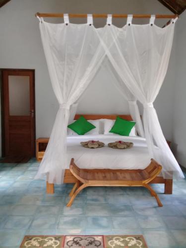 希德门Loka Amertha的一间卧室配有一张带蚊帐的床
