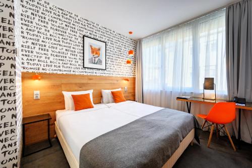 布达佩斯布达佩斯中心鲁姆拜酒店的酒店客房配有一张床、一张桌子和一把椅子。