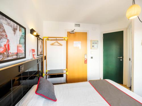圣阿德里安-德贝索斯Hostal Athenas的一间卧室设有一张床和一个绿门