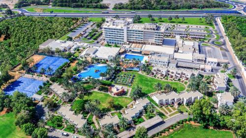 艾恩Radisson Blu Hotel & Resort, Al Ain的享有带游泳池的度假村的空中景致