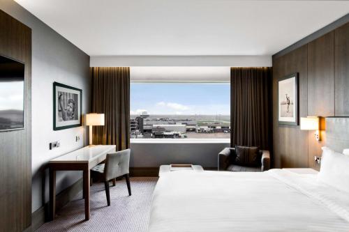 霍尔曼彻斯特机场丽笙布鲁酒店的配有一张床、一张书桌和一扇窗户的酒店客房